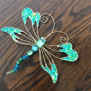 Firefly and butterfly decorative ornament. Fork placed for scale